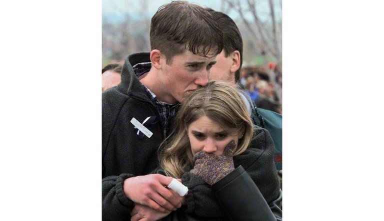 In this Sunday, April 25, 1999, photo Columbine shooting victim Austin Eubanks hugs his girlfriend during a community wide memorial service in Littleton, Colo.