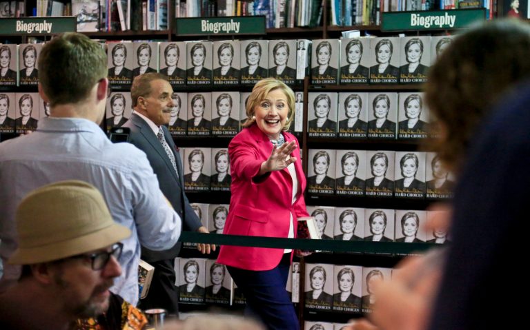 Hillary Clinton, center, waves to a gathering as she arrives for a book signing on Tuesday June 10, 2014, at Barnes and Noble bookstore in New York. (AP Photo/Bebeto Matthews)