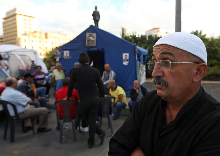 In this Thursday, Oct. 16, 2014 photo, Hamza Hommos, 55, father of Lebanese policeman Wael Hommos, who was kidnapped by Islamic State militants and the Nusra Front, speaks during an interview with The Associated Press in front of his tent set up for their sit-in protest in downtown Beirut, Lebanon. With all eyes on the Islamic State group's onslaught in Iraq and Syria, a less conspicuous but potentially just as explosive frontline with the extremists is emerging in Lebanon, where Lebanese soldiers and Shiite Hezbollah guerrillas are increasingly pulled into deadly fighting with the Sunni militants along the country's border with Syria. (AP Photo/Bilal Hussein)