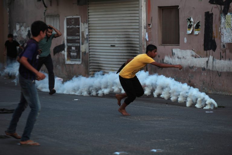 Bahraini anti-government protesters face off against riot police firing tear gas during clashes in Diraz, Bahrain, Friday, May 23, 2014. Clashes erupted in several northern towns after last-minute notification that a planned opposition rally would not be authorized by authorities. Tensions are high in the Gulf island kingdom, following two recent deaths of protesters and delays in releasing the body of another man who died earlier. (AP Photo/Hasan Jamali)