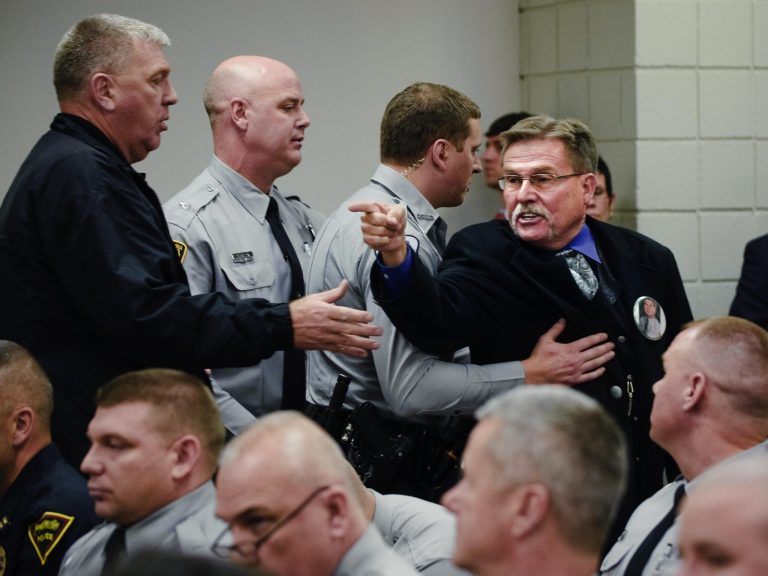   Sheriff's deputies escort Al Lowry, the brother of murdered Highway Patrol Trooper, Ed Lowry after he yelled an expletive at Cumberland County Superior Court Judge Gregory A. Weeks, Thursday, Dec. 13, 2012 in Fayetteville, N.C. Judge Weeks declared the death sentences commuted to life without parole under the Racial Justice Act for Lowry's brother's killer, Tilmon Golphin. Defendants Christina S. 