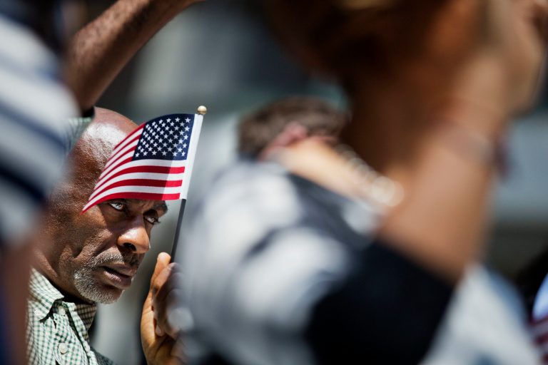 Mamadou Lawal Diallo, of Guinea, takes his Oath of Allegiance at a naturalization ceremony Friday, July 1, 2016, in Atlanta. Nineteen new Americans took their oath as United States Citizens in a ceremony at City Hall ahead of the July 4th holiday Friday. (AP Photo/David Goldman)