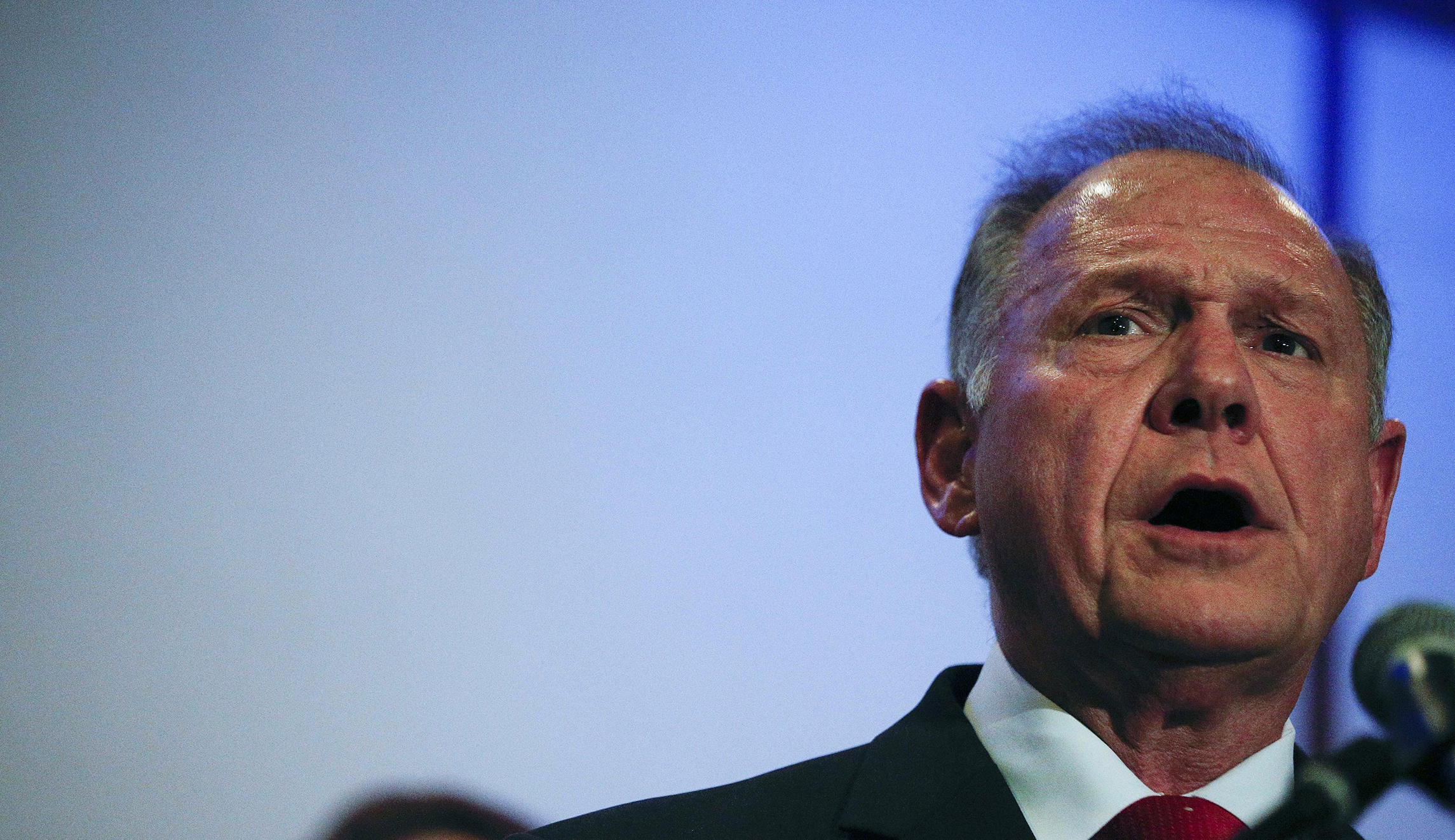 Men with Roy Moore stickers push cameramen outside campaign event