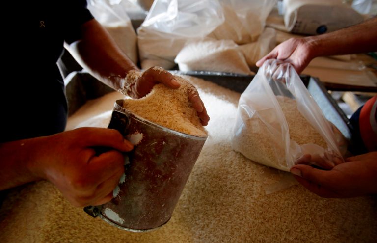 Workers fill bags with rice at a United Nations food aid distribution center, in the Shati refugee camp in Gaza City, Wednesday, Aug. 6, 2014. A cease-fire between Israel and Hamas that ended a month of war was holding for a second day Wednesday, ahead on negotiations in Cairo on a long-term truce and a broader deal for the war-ravaged Gaza Strip. (AP Photo/Hatem Moussa)
