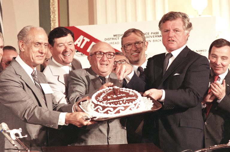 Sen. Edward M. Kennedy, right, joins other members of Congress at a 20-year birthday party celebration for Medicaid and Medicare, July 30, 1985. (AP Photo/J. Scott Applewhite)