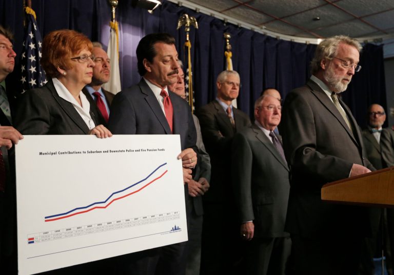 Aurora, Ill., Mayor Tom Weisner, right, accompanied by several mayors and village presidents from across Illinois, speaks during a news conference calling for state lawmakers to overhaul local pension systems for police and fire departments, Monday, April 21, 2014, in Chicago. (AP Photo/M. Spencer Green)