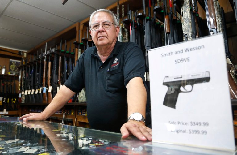 In this Tuesday, Dec. 5, 2017 photo, manager of Bob Moates Sports Shop, David Hancock, poses with a firearm in the shop in Richmond, Va. Hancock says he is not expecting any major changes in the states gun laws as a result of the election of many Democrats in the Virginia House of Delegates. (AP Photo/Steve Helber)