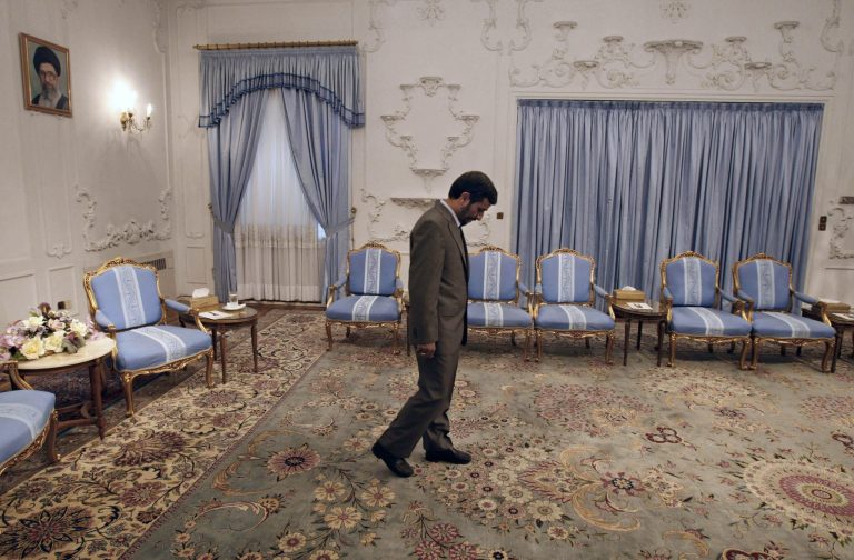   FILE - In this July 11, 2009 file photo, Iranian President Mahmoud Ahmadinejad, waits to receive Omani Foreign Minister Yousuf bin Alawi bin Abdullah at the presidency, in front of a picture of supreme leader Ayatollah Ali Khamenei, in Tehran, Iran. Despite the heavy attention on Iran's external struggles, including sanctions and the shaky rule of critical ally Bashar Assad in Syria, the coming year could be a highly inward-looking one for Iran and Ahmadinejad will be looking ahead for ways to secure some kind of post-presidency political role. (AP Photo/Vahid Salemi, File)  