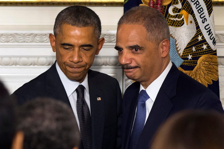 Audience members applaud Attorney General Eric Holder, right, and President Barack Obama during an announcement in the State Dining Room of the White House to announce Holder is resigning, on Thursday, Sept. 25, 2014, in Washington. Holder, who served as the public face of the Obama administration's legal fight against terrorism and weighed in on issues of racial fairness, is resigning after six years on the job. He is the first black U.S.  attorney general. (AP Photo/Evan Vucci)