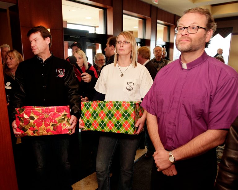   John Riskey, BCTGM Local 167G President, Heidi Durand, Moorhead City Council, and Reverend John Anderson wait for permission to deliver more than 80,000 petitions from across the country to shareholders and growers at the annual American Crystal Sugar Company meeting Thursday, Dec. 6, 2012, in Fargo, N.D. The petitions urge management to end the lockout of workers that enters the 17th month. The group was not allowed to deliver the boxes containing the petitions. (AP Photo/The Forum, Dave Wallis)  