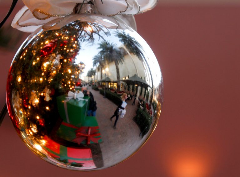   In this Thursday, Dec. 20, 2012, photo, a holiday shoppers reflected in a ornament handing from a large Christmas tree at Fashion Island shopping center in Newport Beach, Calif. Thursday, Dec. 20, 2012. U.S. holiday retail sales this year are the weakest since 2008, after a shopping season disrupted by storms and rising uncertainty among consumers. A report out Tuesday that tracks spending, called MasterCard Advisors SpendingPulse, says holiday sales increased 0.7 percent. Analysts had expected sales to grow 3 to 4 percent. (AP Photo/Chris Carlson)  