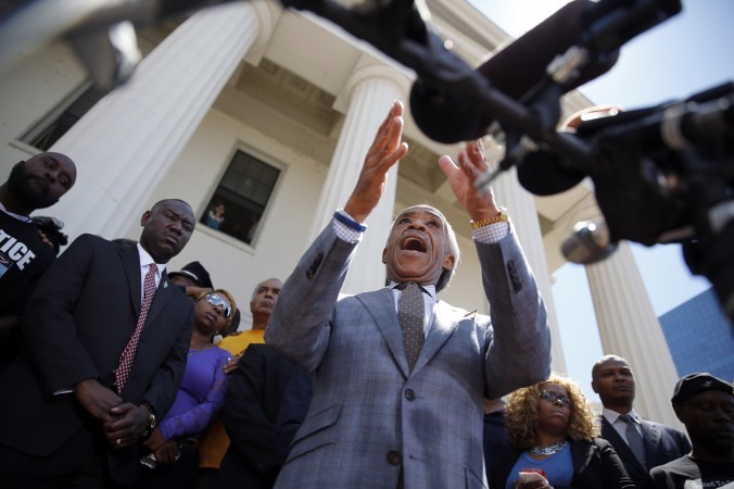 Rev. Al Sharpton during a news conference with (L-R) Michael Brown Sr., Brown family attorney Benjamin Crump, and Lesley McSpadden, Brown's mother in St. Louis on Aug. 12, 2014. (AP Photo/Jeff Roberson)