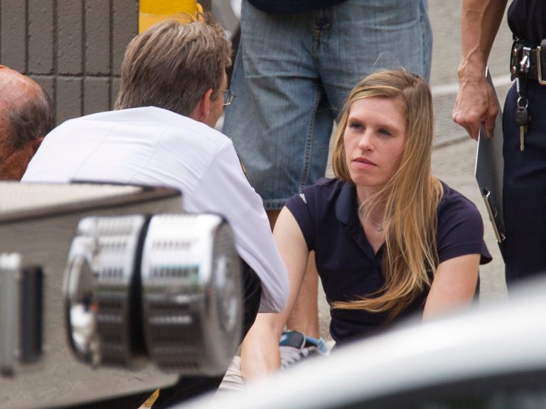 Authorities talk to Julia Link who was piloting the small helicopter that crashed in downtown Honolulu Wednesday, May 8, 2013, The helicopter crashed near the intersection of Fort Street and Beretania Street. The helicopter was on a photography flight when it lost power, forcing a crash landing on Fort Street, which is home to a large apartment complex and Hawaii Pacific University. (AP Photo/Eugene Tanner)