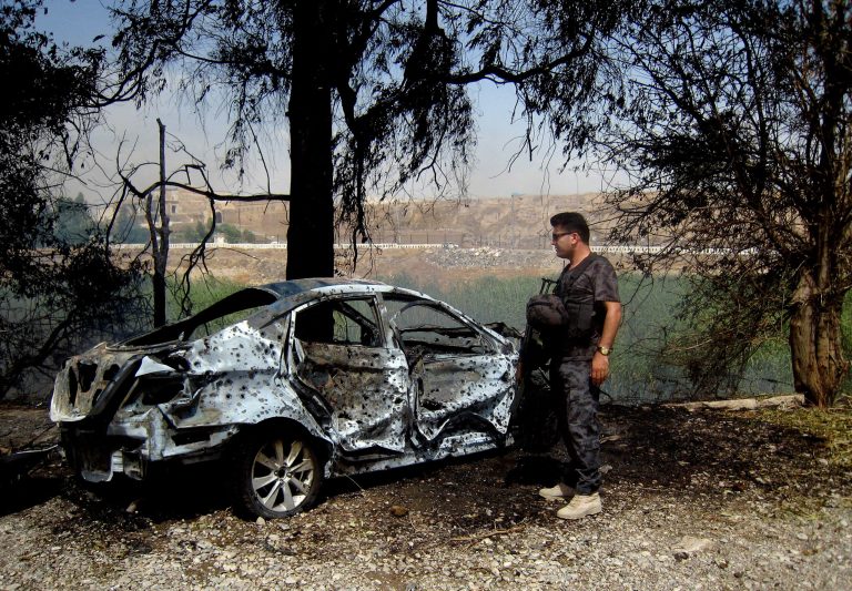 An Iraqi policeman inspects the aftermath of two parked car bomb explosion that hit near a police building and a market in the oil-rich and ethnically-mixed city of Kirkuk, 180 miles (290 kilometers) north of Baghdad, Iraq, Wednesday, June 4, 2014. Iraq is experiencing its worst surge in violence since the sectarian bloodletting that nearly tore the country apart in 2006 and 2007. The U.N. says 8,868 people were killed in 2013. (AP Photo/ Emad Matti)