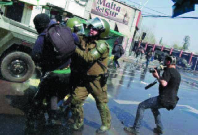 A demonstrator is arrested by anti-riot police during a protest to mark the 39th anniversary of the military coup in Santiago, Chile, Sunday, Sept. 9, 2012. Protesters clashed with police after a march to remember the victims of the dictatorship led by Gen. Augusto Pinochet who toppled leftist President Salvador Allende on Sept. 11, 1973. (AP Photo/Luis Hidalgo)