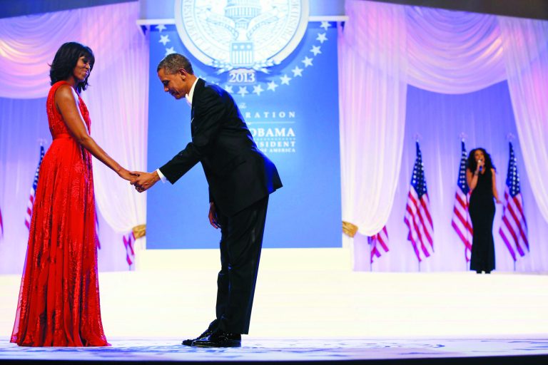 President Barack Obama bows as he and first lady Michelle Obama, wearing a ruby colored chiffon and velvet Jason Wu gown, gets ready to dance as singer Jennifer Hudson, right, sings Al Green's 
