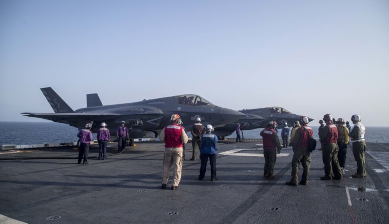 U.S. Marines and Sailors with the Essex Amphibious Ready Group and the 13th Marine Expeditionary Unit wait for flight operations to begin while F-35B Lightning IIs with Marine Fighter Attack Squadron 211, 13th MEU, are refueled in preparation for the F-35B's first combat strike on Thursday.