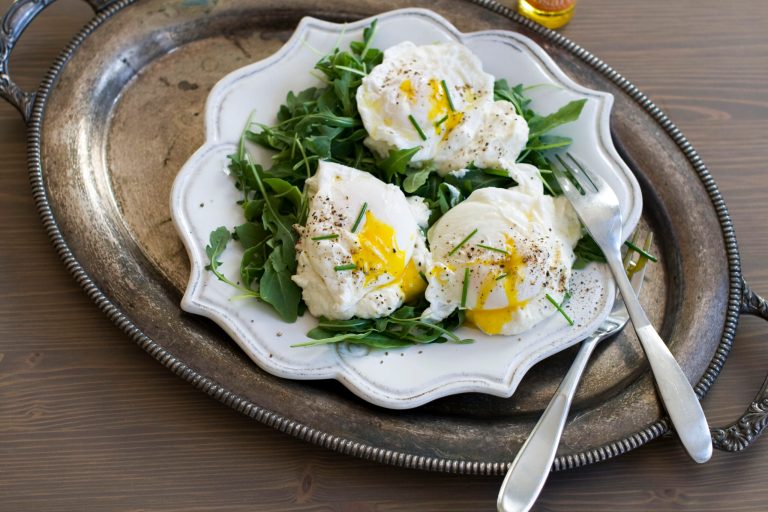   In this image taken Dec. 3, 2012, poached eggs over ricotta cheese on arugula are shown served on a plate in Concord, N.H. (AP Photo/Matthew Mead)  