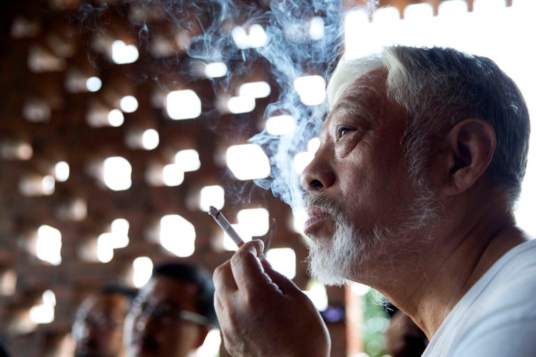 In this photo taken Sunday, Aug. 24, 2014, Li Xianting, a film critic and founder of the Li Xianting Film Fund, the organizer of the Beijing Independent Film Festival smokes as he meets journalists after he was released in Beijing, China. China is avidly wooing filmmakers to create more documentaries to replace popular dating, reality and game shows. But it is also stifling material with any whiff of challenging the Communist Party line. (AP Photo/Ng Han Guan)