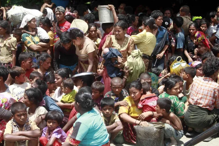 Muslims women and children from villages gather before being relocated to secure areas in Sittwe, capital of Rakhine state in western Myanmar, where sectarian violence is ongoing Tuesday, June 12, 2012. Gunshots rang out and residents fled blazing homes in western Myanmar on Tuesday as security forces struggled to contain deadly ethnic and religious violence that has killed at least a dozen people and forced thousands to flee. (AP Photo/Khin Maung Win)