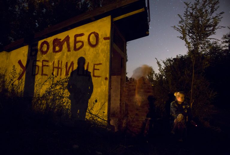 Local residents sit near an entrance to a bomb shelter as they exit to get some fresh air during a short cease fire in Petrovsky district in the city of Donetsk, eastern Ukraine Tuesday, Aug. 5, 2014. (AP Photo/Dmitry Lovetsky)