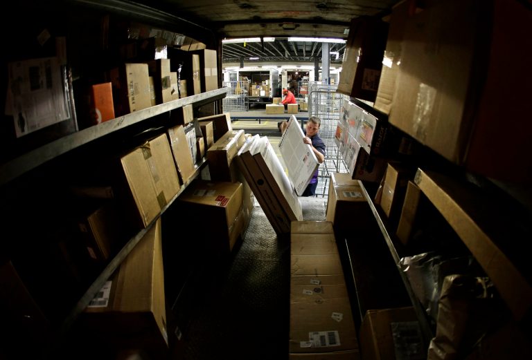 FILE - In this Monday, Dec. 16, 2013, file photo, driver Kyle Woodroof loads packages in his delivery truck, Monday, Dec. 16, 2013, in Kansas City, Mo. Th e Commerce Department reports how much wholesalers adjusted their stockpiles in November and how much their sales changed on Friday, Jan. 10, 2014. (AP Photo/Charlie Riedel, File)