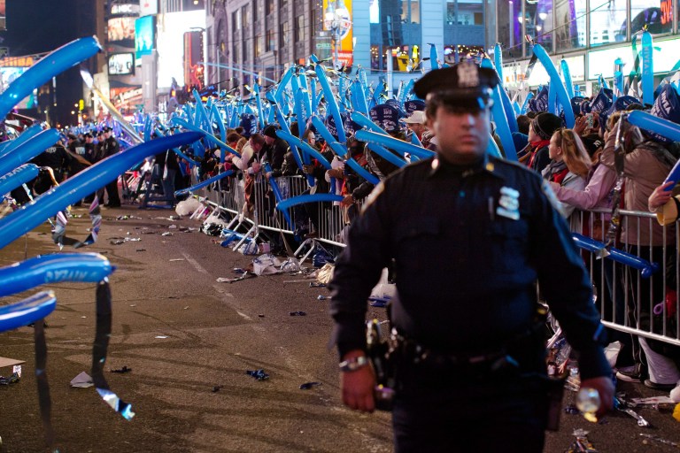   FILE - In this Dec. 31, 2011 file photo, a police officer walks through a frozen zone in New York Cityâs Times Square as revelers wave balloons in anticipation of midnight. The New York City police use an array of security measures for the event that turns the 
