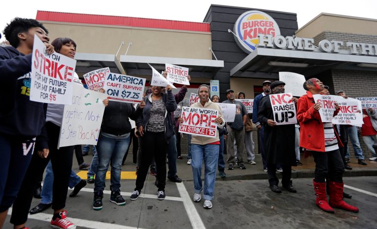 Protestors chant outside a Burger King restaurant during a protest for a raise in the minimum wage in Charlotte, N.C., Thursday, Dec. 5, 2013. Fast food workers across the country walked off their jobs to fight for a $15 an hour wage. (AP Photo/Chuck Burton)