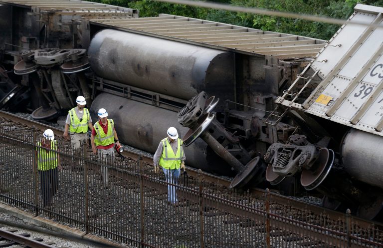 Officials walk past part of a CSX freight trail that derailed in Ellicott City. (AP Photo)