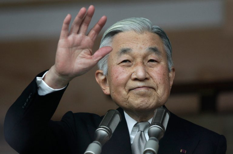   Japan's Emperor Akihito waves to a crowd of well-wishers through the bulletproof glass of a balcony, during a morning appearance to mark his 79th birthday, at the Imperial Palace in Tokyo Sunday, Dec. 23, 2012. (AP Photo/Shizuo Kambayashi)  