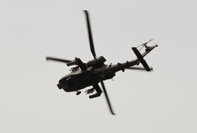A U.S. military AH-64 Apache attack helicopter flies above a road outside Ploiesti, Romania, Wednesday, May 13, 2015. The defense bill includes money to procure Apaches. (AP Photo/Vadim Ghirda)