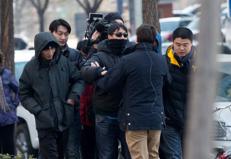 A foreign journalist, second right showing his back, is pushed away by a plainclothes policeman while he and his crew are covering a trial of legal scholar and founder of the New Citizens movement Xu Zhiyong near the No. 1 Intermediate People's Court in Beijing Wednesday, Jan. 22, 2014. The trial of the prominent activist who has led a grassroots campaign demanding a fairer society and official accountability to better fight corruption started in Beijing, while police blocked journalists and supporters from getting near. Xu stood trial Wednesday, accused of disrupting public order.  (AP Photo/Andy Wong)
