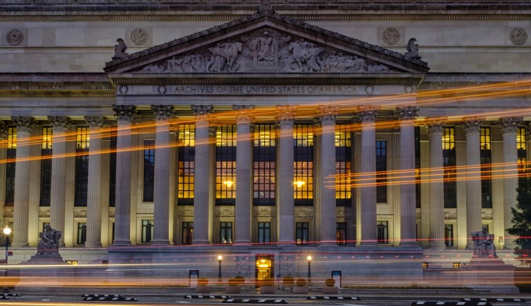 Traffic streaks past the U. S. National Archive headquarters building early in the morning, Tuesday, Oct. 24, 2017. President Donald Trump announced last week he intendeds to allow the National Archive to release additional classified documents on the assassination of President John F. Kenney. (AP Photos/J. David Ake)