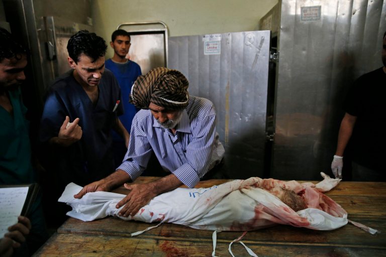 Palestinian Ahmed Jadallah, centre, 75, prepares a child's body for burial at the morgue of Kamal Adwan hospital in Beit Lahiya, northern Gaza Strip, Thursday, July 24, 2014. Over the past three decades, the 75-year-old Jadallah has dressed hundreds of 'martyrs' _ those killed in conflict with Israel. He said his volunteer work fulfills an Islamic commandment and that he hopes it will earn him a place in paradise. (AP Photo/Lefteris Pitarakis)