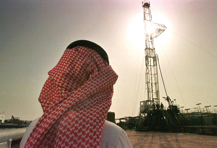 An official of the Saudi oil company Aramco watches progress at a rig at the al-Howta oil field near Howta, Saudi Arabia. (AP Photo/John Moore)