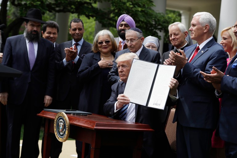 President Trump holds a signed executive order aimed at easing an IRS rule limiting political activity for churches, Thursday, May 4, 2017, in the Rose Garden of the White House in Washington. (AP Photo/Evan Vucci)