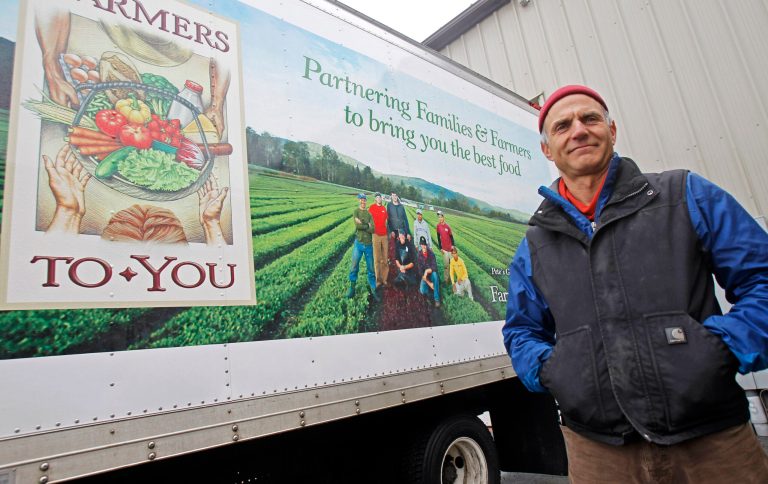  In this Monday, Dec. 10, 2012 photo, Greg Georgaklis stands next to one of his delivery trucks at Farmers To You in Berlin, Vt. The online distributor that delivers weekly bundles of Vermont-produced foods to more than 375 families in Boston is expanding to link even more Vermont farmers to consumers in the city far away. (AP Photo/Toby Talbot)  