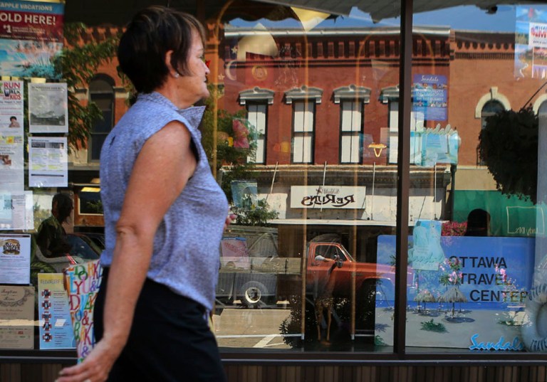   FILE - In this Aug. 1, 2013 file photo, a shopper strolls past a storefront in downtown Ottawa, Ill. The private Conference Board reports on consumer confidence for August on Tuesday, Aug. 27 , 2013. (AP Photo/NewsTribune, Genna Ord, File)  