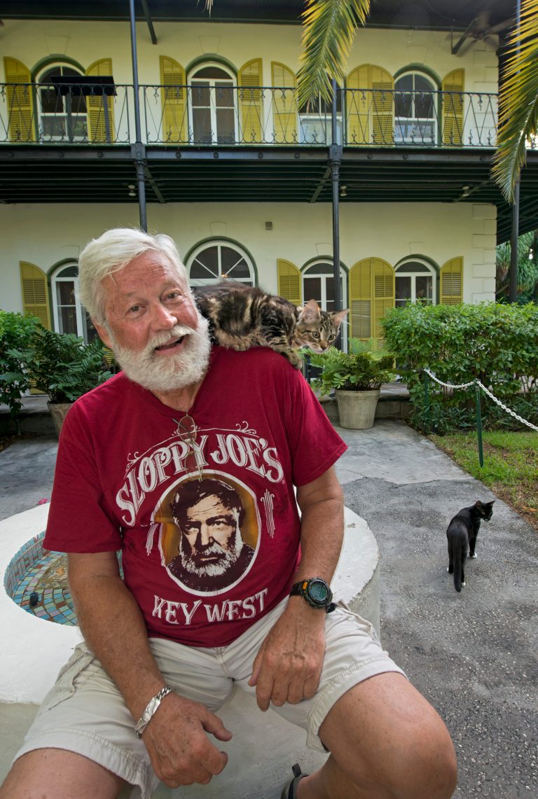 In this photo provided by the Florida Keys News Bureau, Wally Collins poses in front of the Ernest Hemingway Home & Museum Sunday, July 20, 2014, in Key West, Fla. Collins, a Phoenix restaurateur, won the 2014 