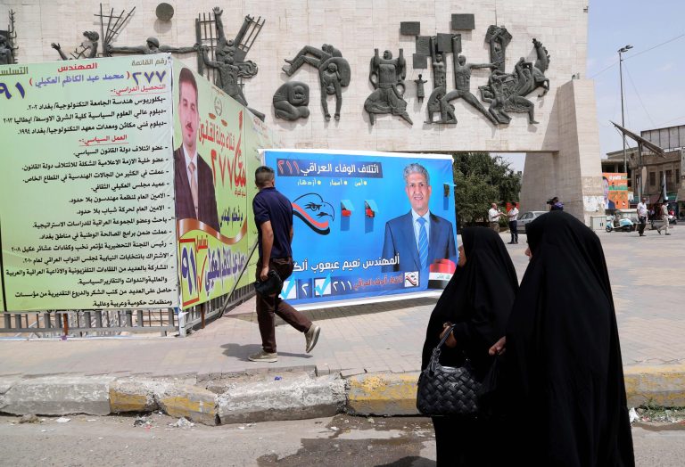 People walk past election campaign posters at Tahrir Square in Baghdad, Iraq, Thursday, April 10, 2014. The election campaign kicked off Tuesday, April 1, 2014 with Iraqi towns and cities flooded with posters of the candidates for parliament seats on main streets and intersections. The vote is set for April 30. (AP Photo/Karim Kadim)