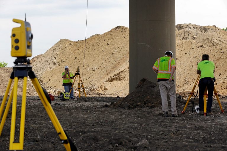 Surveyors stand near a tilting support column that is holding up the Interstate 495 bridge over the Christina River near Wilmington, Del., Tuesday, June 3, 2014, after it was closed due to the discovery of tilting support columns. The closure created heavier-than-normal traffic conditions for motorists on Interstate 95, a major East Coast artery. The bridge normally carries about 90,000 vehicles a day. (AP Photo/Patrick Semansky)