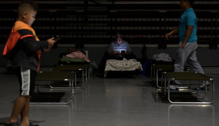 A man watches his cell phone while waiting at Humacao Arena refugee center for the imminent impact of Maria, a Category 5 hurricane that threatens to hit the eastern region of the island with sustained winds of 175 miles per hour, in Humacao, Puerto Rico, Tuesday, September 19, 2017. About 137 citizens arrived at the refuge from different parts of the eastern region of the Island. (AP Photo/Carlos Giusti)