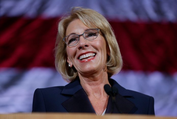 FILE - In this Oct. 13, 2017 file photo, U.S. Education Secretary Betsy DeVos speaks during a dinner hosted by the Washington Policy Center in Bellevue, Wash. The Associated Press has learned the Education Department is considering only partially forgiving federal loans for students defrauded by for-profit-colleges. That would mean abandoning the Obama administration's policy of fully erasing that debt. Under President Barack Obama, tens of thousands of students deceived by now-defunct for-profit schools had over $550 million in such loans canceled completely. The possible change could leave many students scrambling after expecting full forgiveness. (AP Photo/Ted S. Warren, File)