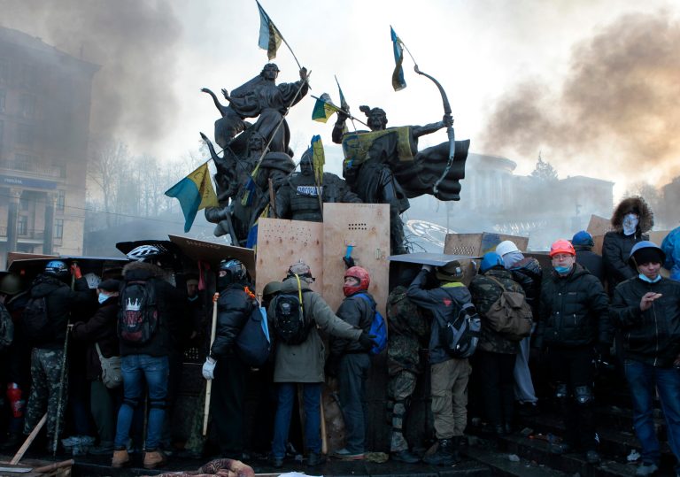 Anti-government protesters protected themselves with shields during clashes with riot police in Kiev's Independence Square, the epicenter of the country's current unrest, Kiev, Ukraine, Wednesday, Feb. 19, 2014. The deadly clashes in Ukraine's capital have drawn sharp reactions from Washington, generated talk of possible European Union sanctions and led to a Kremlin statement blaming Europe and the West. (AP Photo/Sergei Chuzavkov)