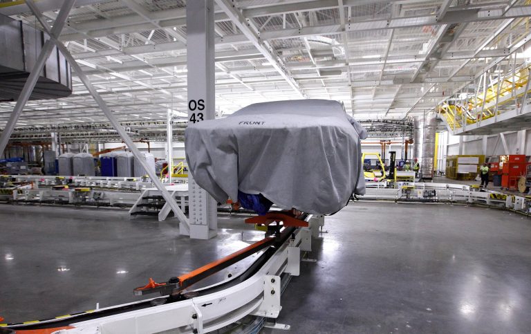   FILE - In this Tuesday, July 16, 2013, file photo, a covered vehicle sits in part of the new paint shop at Chrysler's Sterling Heights Assembly Plant in Sterling Heights, Mich. The Commerce Department reports on wholesale prices for July on Wednesday, Aug. 14, 2013. (AP Photo/Paul Sancya, File)  