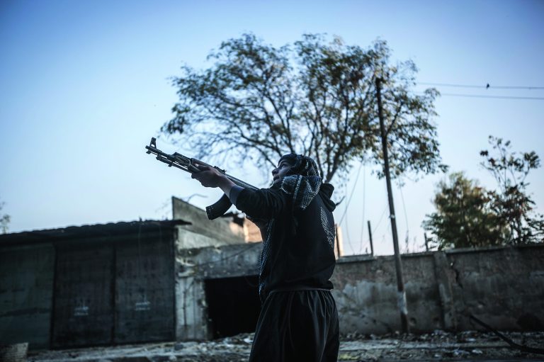 In this Saturday, Oct. 27, 2012 photo, a rebel fighter looks over the street as he prepares himself to run through a sniper line-of -fire in the southeast area of Aleppo, Syria. (AP Photo/Narciso Contreras).