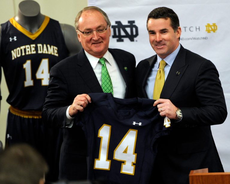 Jack Swarbrick, left, Notre Dame Vice President and Director of Athletics, left, and Kevin Plank, CEO and founder of Under Armour, hold up a jersey during a news conference Tuesday Jan. 21, 2014, in South Bend, Ind., announcing an agreement between Notre Dame and Under Armour that will outfit the university's athletic teams  (AP Photo/Joe Raymond)