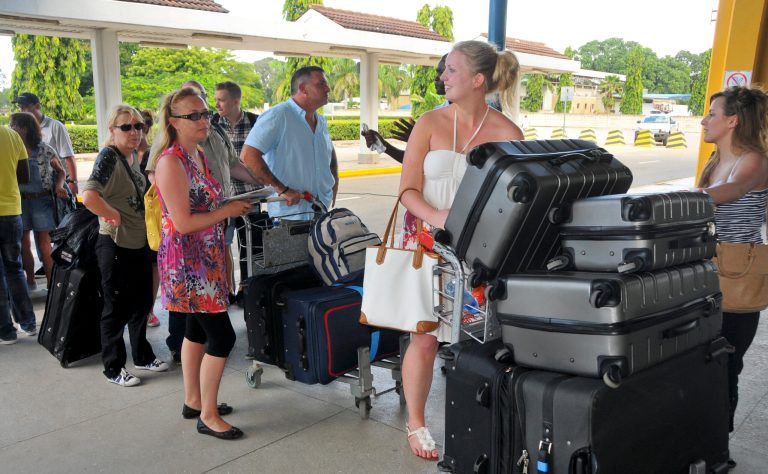 British tourists queue with their luggage to leave by charter flight from the international airport in Mombasa, Kenya Friday, May 16, 2014. Britain's government warned its citizens this week to avoid the coastal city of Mombasa and beach towns nearby, prompting a travel company to cut short the vacations of hundreds of British citizens and fly them home, while Kenya's National Disaster Operation Centre says that two explosions in Nairobi have killed at least four people Friday with one blast targeting a mini-van that Kenyans use for public transportation and a second blast went off in a market. (AP Photo)