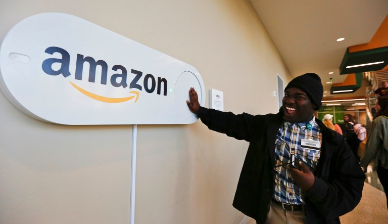 In this Monday, Oct. 16, 2017, photo, Zavian Tate, a student at the University of Alabama at Birmingham, pushes a large Amazon Dash button, in Birmingham, Ala. The large Dash buttons are part of the city's campaign to lure Amazon's second headquarters to Birmingham. (AP Photo/Brynn Anderson)
