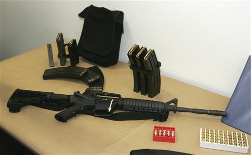 FILE - This March 27, 2006 file photo, shows a Bushmaster AR-15 semi-automatic rifle and ammunition on display at the Seattle Police headquarters in Seattle. The maker of the Bushmaster rapid-fire weapon used to kill schoolchildren in Connecticut on Friday, Dec. 14, 2012, was put up for sale on Tuesday, Dec. 18, 2012, as investors soured on the gun business. (AP Photo/Ted S. Warren, File)